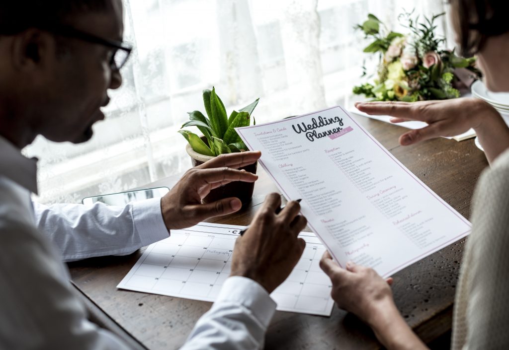 Couple reviewing a wedding planner checklist together at a table